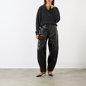 Model wearing Loulou Studio Malo Half-Buttoned Sweater in Ivory with black leather barrel-leg trousers and black heels.