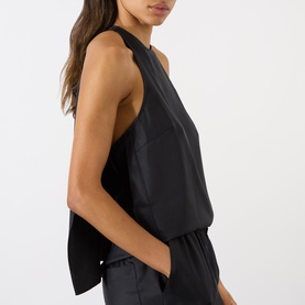 Model wearing Loulou Studio Cami Silk Cape Top in black, showing sleeveless silhouette with cape-like back panel, paired with black trousers.