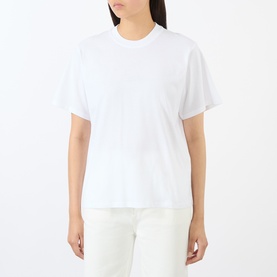 Model wearing Loulou Studio white cotton crew-neck T-shirt, styled with white wide-leg trousers.