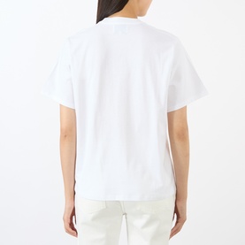 Model wearing Loulou Studio white cotton T-shirt, back view, styled with white trousers, relaxed short-sleeve fit