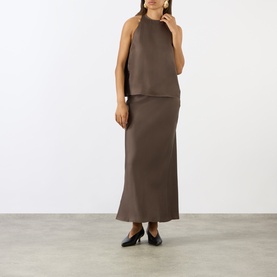 Model wearing Loulou Studio dark brown silk halterneck top, styled with matching maxi skirt and black heels