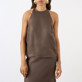 Model wearing Loulou Studio dark brown silk halterneck top, styled with matching skirt and gold earrings.