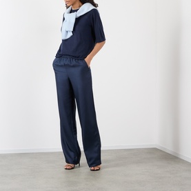 Model wearing Loulou Studio Nala Cashmere Sweater in navy, short sleeves, round neck, styled with matching navy wide-leg trousers and a light blue