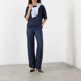 Model wearing Loulou Studio navy silk wide-leg trousers, styled with a matching navy top and light blue scarf.