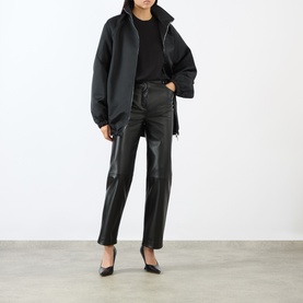Model wearing Loulou Studio black lambskin leather trousers, styled with a black oversized jacket and black pointed heels.