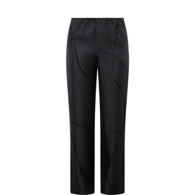 Loulou Studio black silk trousers with curved seam detailing, elasticated waist, and straight-leg silhouette