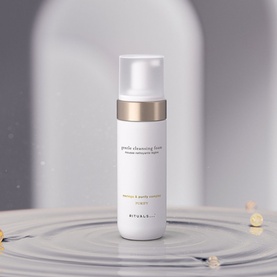 Rituals Gentle Cleansing Foam in white pump bottle with gold band, shown on reflective surface with subtle water ripples