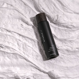 Rituals Homme Shave Foam in a black cylindrical bottle with dark cap, shown on white fabric