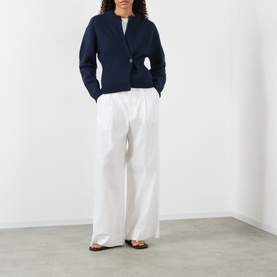 Model wearing Soeur navy merino wool cardigan with single button fastening, styled with wide-leg white trousers and tan sandals