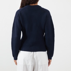 Model wearing Soeur navy merino wool cardigan, back view, styled with white wide-leg trousers