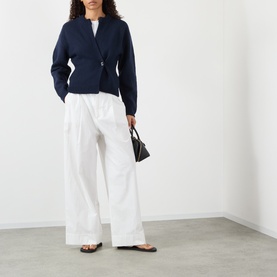 Model wearing Soeur navy merino wool cardigan with belted waist, styled with wide-leg white trousers and black flat sandals