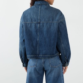 Model wearing Soeur mid blue denim jacket, rear view, with matching wide-leg denim jeans. Relaxed fit, cropped length, 100% cotton.