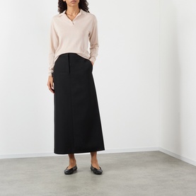 Model wearing Soeur light pink merino wool knit polo top, styled with a black midi skirt and black ballet flats