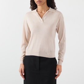 Model wearing Soeur light pink merino wool polo neck knit top, styled with a black midi skirt