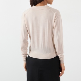Model wearing Soeur light pink merino wool knit sweater, back view, styled with black wide-leg trousers