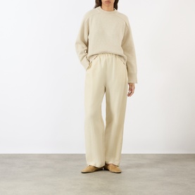Model wearing Soeur ecru chin&eacute; merino wool knit sweater with matching wide-leg trousers and tan flat shoes.