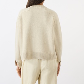 Model wearing Soeur ecru chine merino wool knit sweater, back view, styled with matching wide-leg trousers