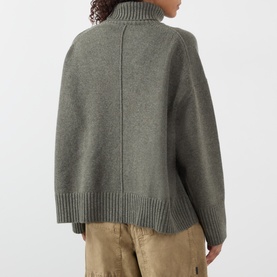 Model wearing Soeur grey merino wool turtleneck knit sweater, back view, styled with tan trousers