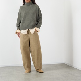 Model wearing Soeur grey merino wool turtleneck knit, styled with a cream shirt and wide-leg camel trousers