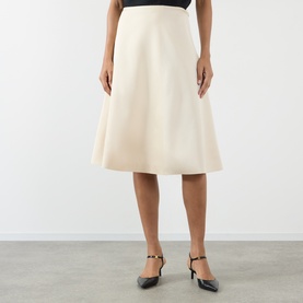 Model wearing Soeur cream midi skirt in A-line silhouette, styled with black slingback heels