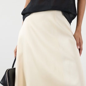 Model wearing Soeur cream viscose midi skirt with black top and small black bag.