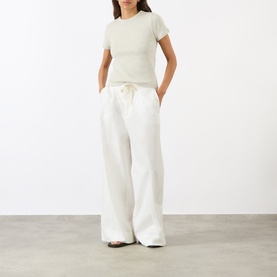 Model wearing Soeur Charcoal cotton T-shirt, styled with wide-leg cream drawstring trousers.