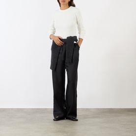 Model wearing Soeur white cotton long-sleeve T-shirt, styled with dark wide-leg trousers and black loafers.