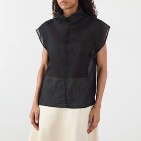 Model wearing Soeur black sheer sleeveless top with funnel neck, styled with a cream midi skirt.