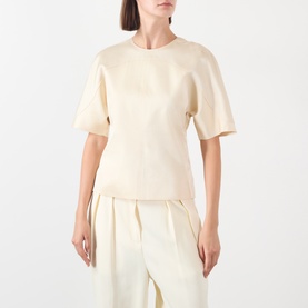 Model wearing Soeur cream short-sleeve top in 100% viscose, styled with matching cream wide-leg trousers.
