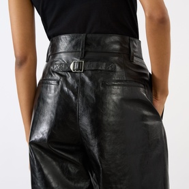 Model wearing Soeur black lambskin leather trousers with buckle belt detail, close-up back view showing waistband and hip