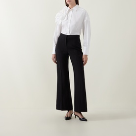 Model wearing Ted Baker black wide-leg trousers with high waist, styled with white shirt and black slingback heels.