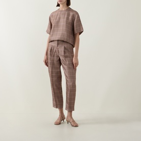 Model wearing Ted Baker beige check tailored trousers, styled with matching check top and nude strappy heeled sandals.