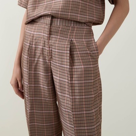 Model wearing Ted Baker beige check wide-leg trousers with elasticated waist, styled with matching short-sleeve top