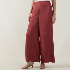 Model wearing Ted Baker Burnt Red wide-leg trousers in satin finish, styled with tan strappy heeled sandals.