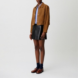 Model wearing Claude Pierlot tan suede cropped jacket with black leather mini skirt, blue striped shirt, navy socks and brown loafers