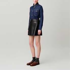 Model wearing Claude Pierlot blue denim shirt with chest pockets, styled with black leather mini skirt and brown leather loafers.