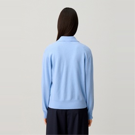 Model wearing Claude Pierlot Logo Polo Sweater in sky blue with shirt collar and gold-tone button, styled with navy wide-leg trousers