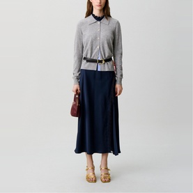 Model wearing Claude Pierlot Fine Knit Cardigan in mottled grey with shirt collar, styled with navy midi skirt, black belt, and tan platform sandals.