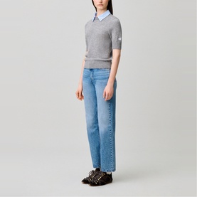 Model wearing Claude Pierlot Collar Knit Sweater in black, short sleeves, removable striped collar, styled with light blue wide-leg jeans.