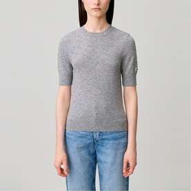 Model wearing Claude Pierlot Collar Knit Sweater in black, short-sleeve wool knit with logo cuff embroidery, styled with blue jeans