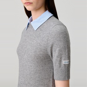 Model wearing Claude Pierlot Collar Knit Sweater in black, short sleeves, with removable blue striped poplin collar and logo cuff detail.