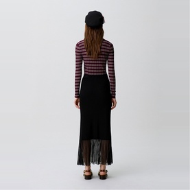 Model wearing Claude Pierlot Rib Knit Skirt in black, maxi length with sheer fringed hem, styled with a striped long-sleeve top and black beret.