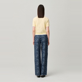 Model wearing Claude Pierlot Contrast Knit T-Shirt in Clear with scalloped trim, styled with navy blue wide-leg printed trousers.