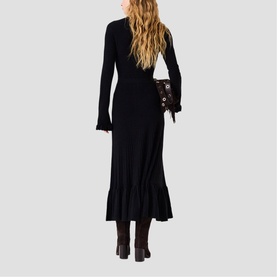 Model wearing Maje Womens French Dress in red, long-sleeve midi length with ruffle hem, styled with dark boots and small crossbody bag