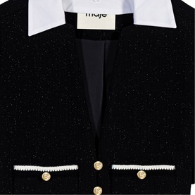 Black tweed blazer with white collar, pearl-trimmed pockets and gold buttons, close-up detail view