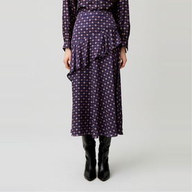 Model wearing Claude Pierlot navy print polka dot midi skirt with asymmetric ruffle hem, styled with black knee-high boots and matching printed top.