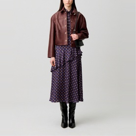 Model wearing Claude Pierlot Womens French Dress in navy print with ruffle tiers, styled with a burgundy leather jacket and black knee-high boots.