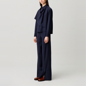 Model wearing Claude Pierlot Shawl Draped Jacket in blue with matching wide-leg trousers and brown loafers