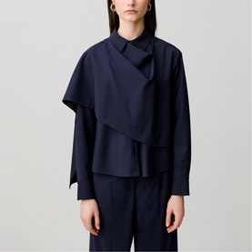 Model wearing Claude Pierlot Shawl Draped Jacket in blue with draped shawl panel, shirt collar, and long sleeves, styled with wide-leg trousers.