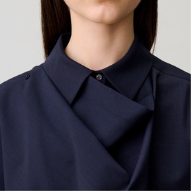 Model wearing Claude Pierlot Shawl Draped Jacket in blue, close-up showing shirt collar and draped fabric panel with button fastening detail